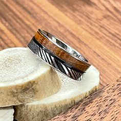 two rings sitting on top of a piece of wood next to a slice of bread