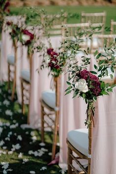 rows of chairs with flowers and greenery on them