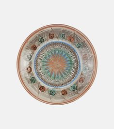 a decorative plate with an intricate design on the front and center, set against a white background