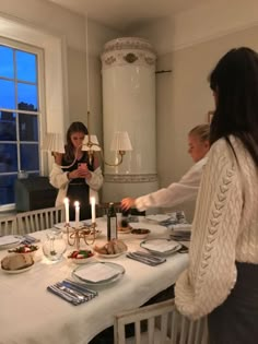 a group of people standing around a dining room table