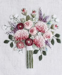 a bouquet of flowers is stitched onto a piece of fabric with thread and beads