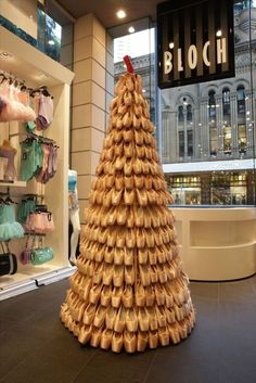 a christmas tree made out of shoes in front of a store window with the word bloch written on it