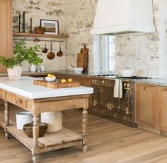 a kitchen with an island in the middle and wooden cabinets on both sides, surrounded by wood flooring