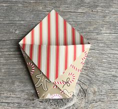 an origami christmas decoration on top of a piece of paper with candy canes