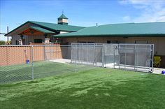 a fenced in baseball field next to a building