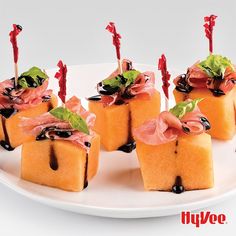 small food items on a white plate with red and green ribbons in the middle,