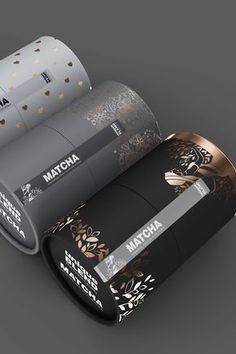 two rolls of matcha are sitting next to each other on a gray surface with gold and black designs