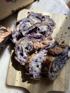 sliced blueberry bread sitting on top of a wooden cutting board