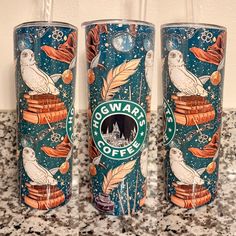 three starbucks cups sitting on top of a counter next to each other with owls and stars painted on them