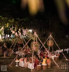 people are sitting at tables with lights strung from the poles and baskets in front of them