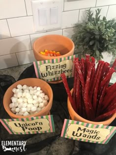 three bowls filled with marshmallows on top of a counter next to a potted plant