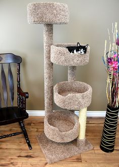 a cat sitting on top of a scratching tower