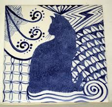 a blue and white tile with a cat on it