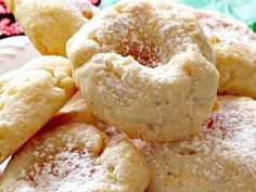 powdered sugar cookies are piled on top of each other in front of a plate