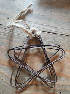 a wire star ornament on a wooden table with some twine around it