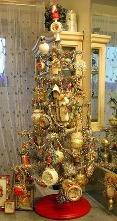 a christmas tree is decorated with ornaments and other items in gold, red, white and silver