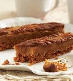 two pieces of cake sitting on top of a white plate next to a fork and cup