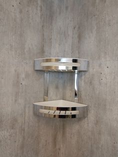 two circular mirrors mounted to the side of a wall next to a metal shelf on concrete