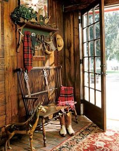 an old rocking chair in the corner of a room with wood paneling and windows