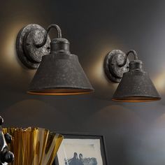 three lights are hanging on the wall above a vase and other items in a room