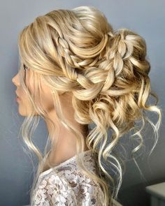 a woman with long blonde hair in a half updo and braids on her head