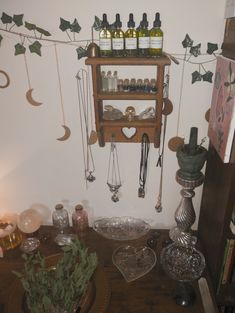 a wooden table topped with lots of glassware and bottles on top of it's shelves