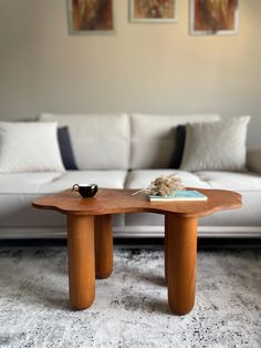 a coffee table sitting in front of a couch with pillows on it's back