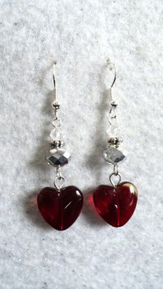 Beautiful heart dangle earrings designed with glass and crystal beads in the colors of red, silver, and clear. The red glass heart measures 1/2 inch in width and length. I have also added silver daisy spacer beads and floral bead caps to the design as well. The ear wires are silver plated and nickel free. The earring drop measures 1 1/2 inches in length. #51 L(4) This beauty was designed and handmade by me with a lot of love. This item will be shipped in a white jewelry box and colorful organza bag. 10% of my sales will be donated a NO-KILL animal shelter in my area.  www.animalhouseshelter.com Valentine Earrings Diy, Valentine Jewelry Ideas, Handmade Earings, Pearl Earrings Designs, Homemade Necklaces, Valentines Day Jewelry, Red Heart Earrings, Valentines Earrings, Diy Jewelry Inspiration