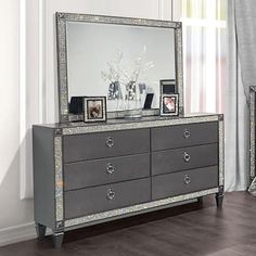 a silver dresser and mirror in a room