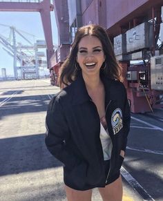 a woman standing in front of a cargo container with her hands on her hips and smiling at the camera