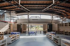 the inside of a building with tables and chairs on each side of the room that is filled with books