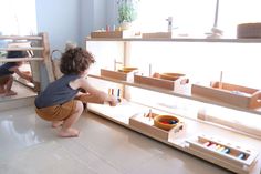 two children are playing with toys on the floor in front of bookshelves and shelves