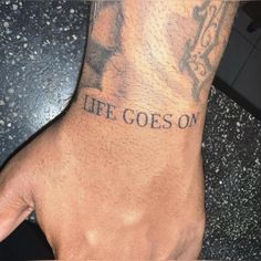 a man with a tattoo on his arm that says life goes on