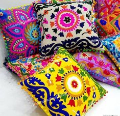 brightly colored pillows are arranged on a white surface