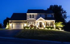 a house lit up at night with the lights on