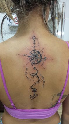 a woman with a compass tattoo on her back