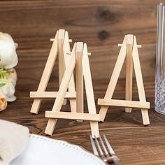 two wooden easels sitting on top of a table next to a knife and fork