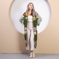 a woman standing in front of a white circle wearing a green and multicolored jacket