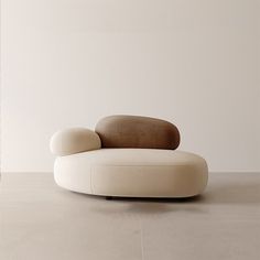 a white couch sitting on top of a wooden floor next to a chair with a brown cushion