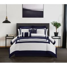 a bed with blue and white comforters in a room