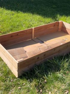 an empty wooden box sitting in the grass