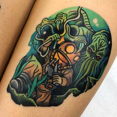 a tattoo on the leg of a woman with an image of two monsters in front of her