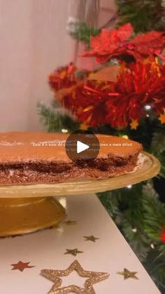 a cake sitting on top of a table next to a christmas tree with red and gold decorations