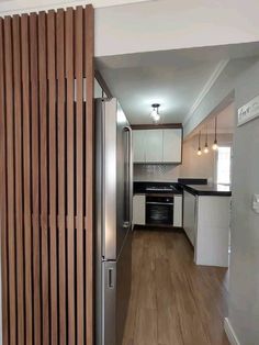 an empty kitchen with wood slats on the wall and flooring in front of it