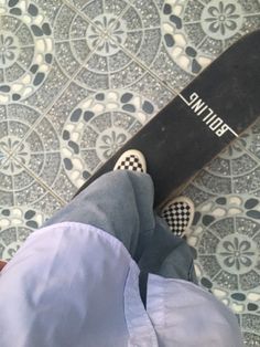 a person standing next to a snowboard on top of a tiled floor