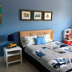 a child's bedroom with blue walls and pictures on the wall above the bed