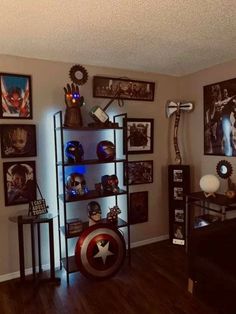 a living room with captain america memorabilia and pictures on the wall, including an iron man busturine