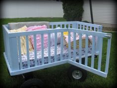 a baby's crib in the grass with blankets on it