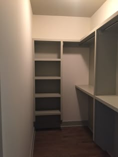 an empty walk in closet with shelves and cabinets