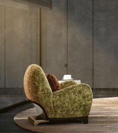 a green chair sitting on top of a wooden floor next to a lamp and table